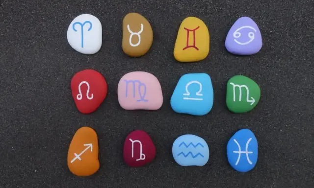 Kolorowe kamienie z symbolami zodiaku ułożone w rzędach. Sprawdź dopasowanie znaków zodiaku!