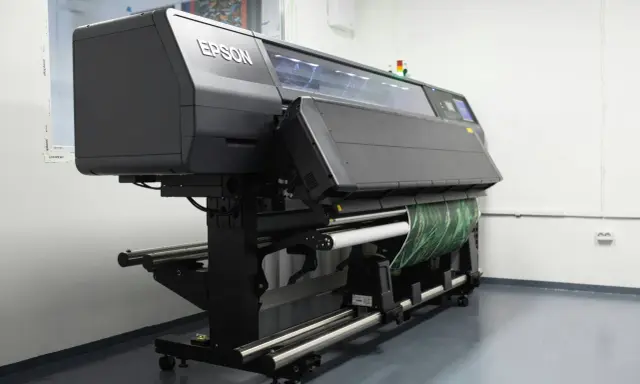 Profesjonalna maszyna Epson do druku solventowego z zielonym wzorem na rolce.