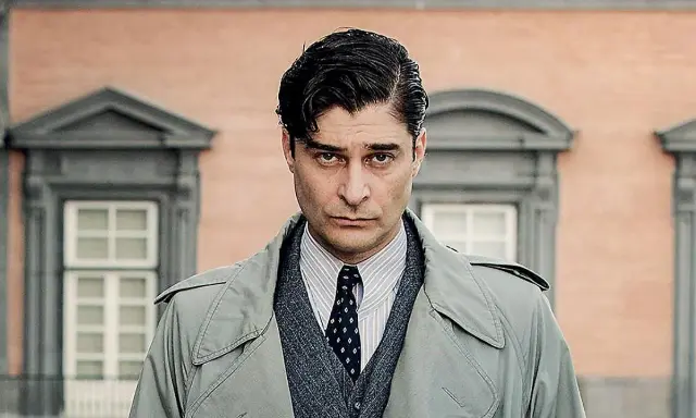 Uomo con trench, camicia a righe e cravatta, con un'espressione seria. Un ritratto creato per mano mia.