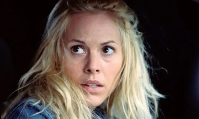 Przerażona kobieta z blond włosami, wpatrzona w coś poza kadrem. Ten moment z filmu sprawia, że widz czuje się jak bohater, oglądając mega wciągające filmy.