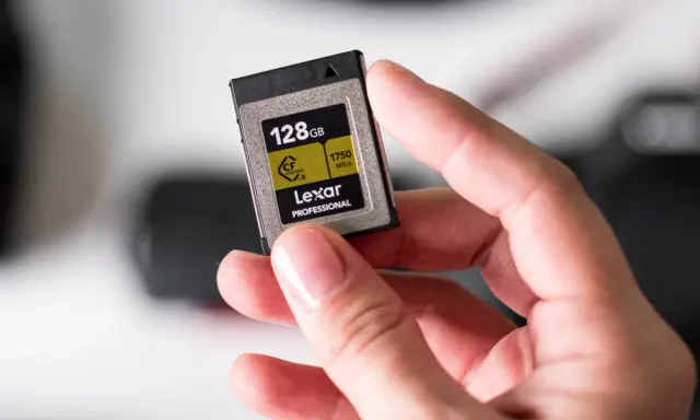 Dłoń trzyma kartę pamięci Lexar Professional 128GB CFexpress B, jedną z najszybszych klas kart pamięci.