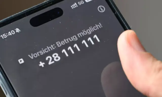 Vorsicht: Betrug möglich! Ein Finger tippt auf dem Smartphone, um Spam-Anrufe zu blockieren.