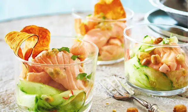 Drei Gläser mit raffinierten Vorspeisen zum Vorbereiten: Lachs-Tatar mit Gurke, Passionsfrucht und knusprigen Chips.