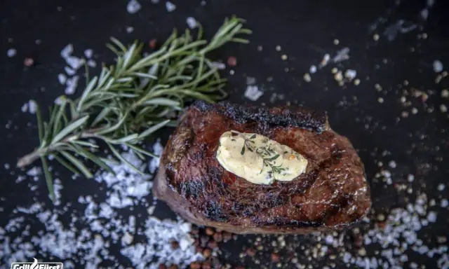 Perfekt medium gegrilltes Steak mit Kräuterbutter, Rosmarin und grobem Salz.