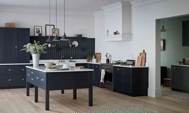Elegancka kuchnia z ciemnogranatowymi, **czarnymi meblami kuchennymi**. Centralna wyspa i zabudowa tworzą spójną całość.