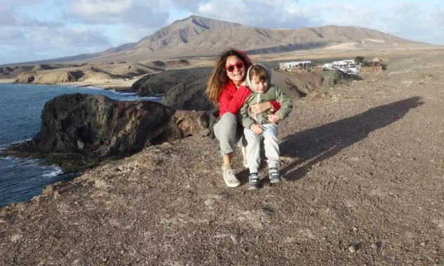 Mamma e bambino felici a Lanzarote con bambini, con vista sulle scogliere e montagne vulcaniche.