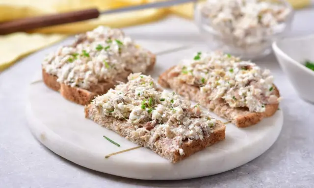 Pyszna pasta z makreli i twarogu na ciemnym pieczywie, posypana szczypiorkiem. Idealna na szybkie śniadanie lub przekąskę.