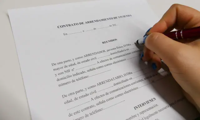Firma de un contrato de arrendamiento de vivienda, un documento legal clave.