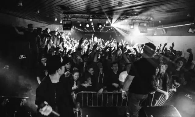 Koncert pro8l3m art brut 2 utwory. Tłum szaleje, artyści na scenie, światła i dym tworzą niepowtarzalny klimat.