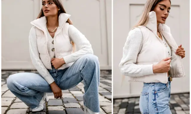 Elegancka stylizacja: jak nosić kamizelkę puchową z jeansami i swetrem. Kremowa kamizelka puchowa, biały sweter z warkoczami, szerokie jeansy i białe botki.