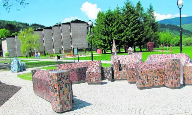 Miniatury budowli z mozaiki, ciekawe wisła atrakcje turystyczne. W tle budynki mieszkalne i zalesione wzgórza.