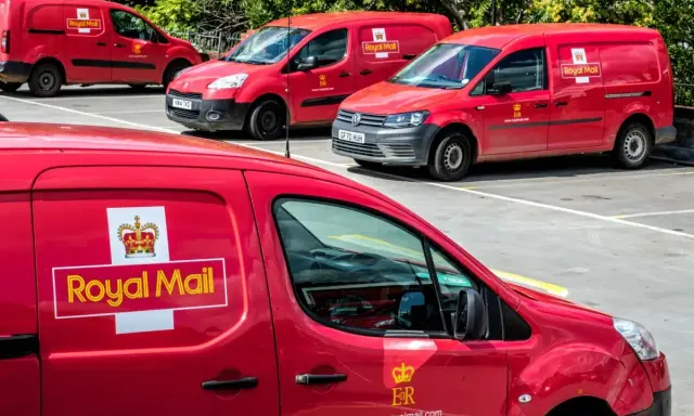 Czerwone furgonetki Royal Mail Polska zaparkowane na placu.