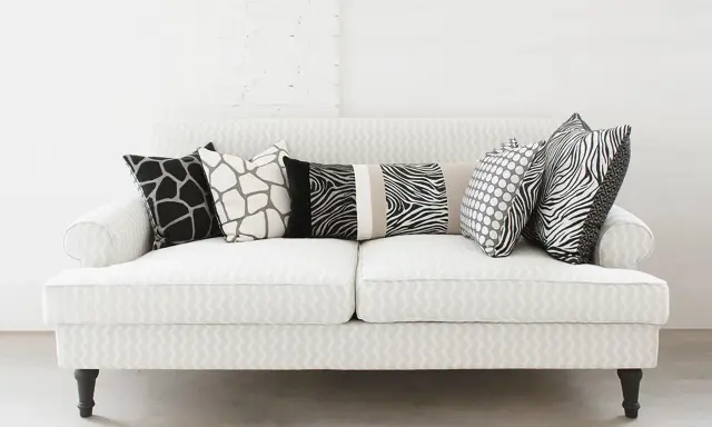 Ecco come mettere i cuscini sul divano: un mix di fantasie animalier e pois per un tocco selvaggio e moderno.