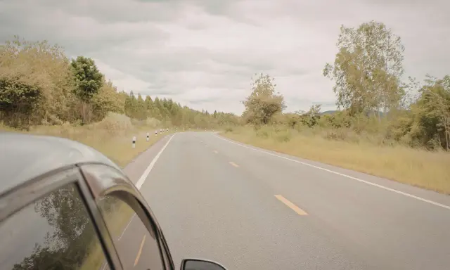 Vista desde un coche en una carretera rural. ¿Cuántos km dura un coche? Depende de su mantenimiento y el camino.