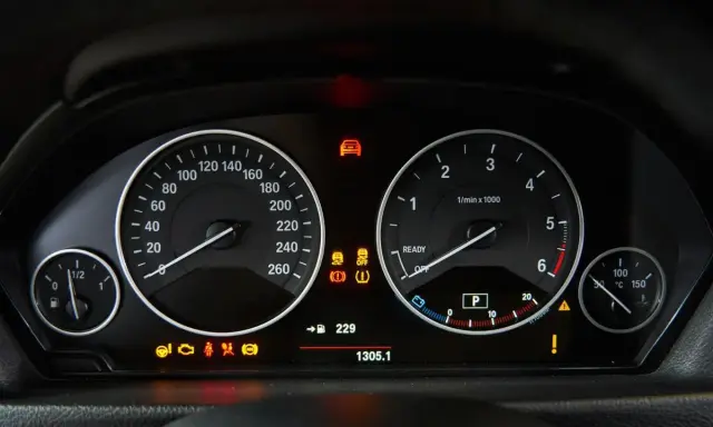 Cruscotto auto con tachimetro, contagiri e spie accese, tra cui il simbolo pressione gomme.