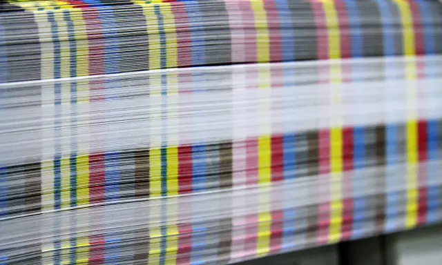 Kolorowe paski CMYK na krawędziach papieru świadczą o pracy w branży poligraficznej.