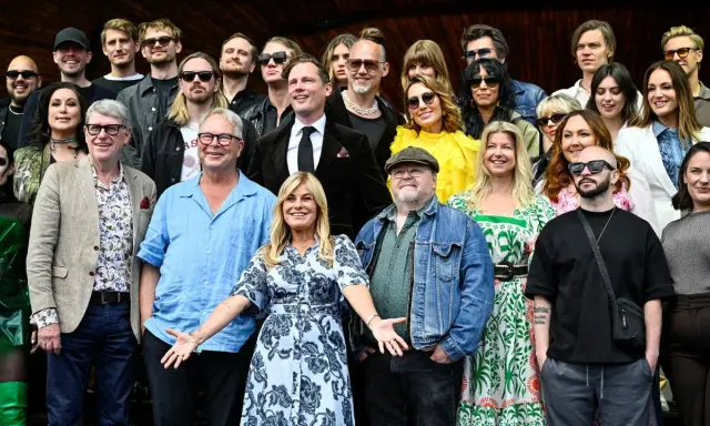 Gruppbild med allsång på Skansen artister. Många glada ansikten i olika åldrar och stilar, redo för en sommarkväll.