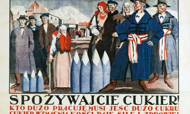 Ludzie w strojach z epoki, przed budynkiem z napisem "Cukier". Hasło "Cukier krzepi kto to powiedział" towarzyszy tej scenie.