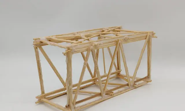 Maqueta de puentes de palos con estructura triangular, unida con pegamento blanco.