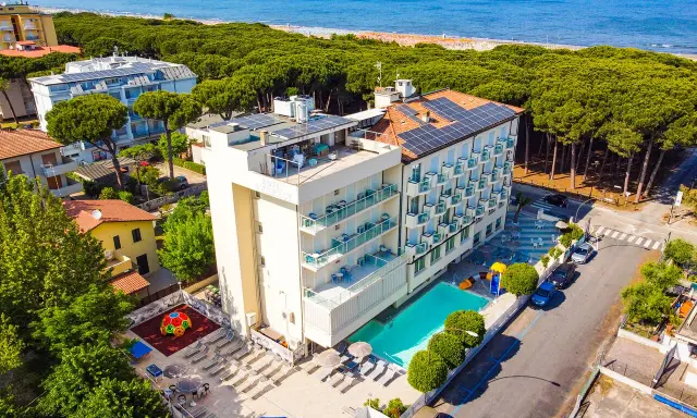 Hotel Primula Azzurra, con piscina, area giochi e vista mare, immerso nel verde di una pineta.