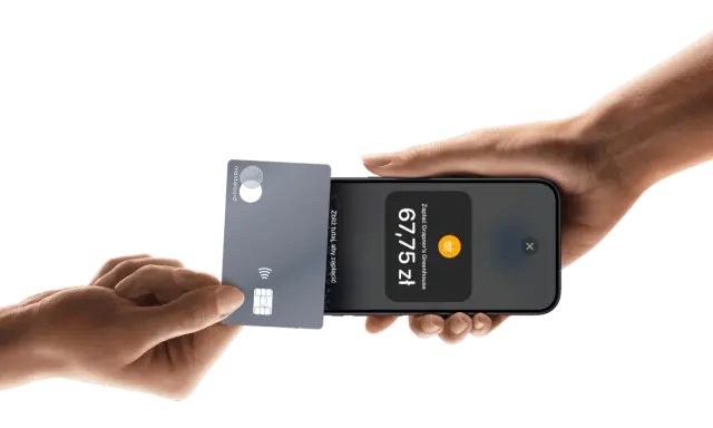 Płatności zbliżeniowe iPhone: karta Mastercard zbliżona do telefonu, wyświetlona kwota 67,75 zł.