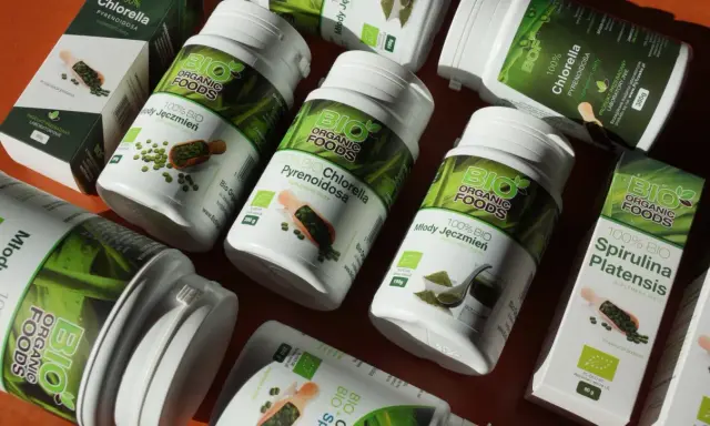 Słoiki i pudełka z produktami **spirulina i chlorella** od Bio Organic Foods. Zielone suplementy diety w proszku i tabletkach.