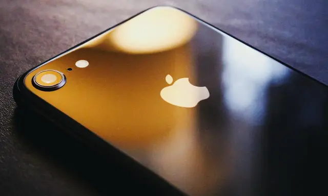 Ciemny iPhone z logo Apple. Dowiedz się, jak zmienić Apple ID, aby zabezpieczyć swoje dane.