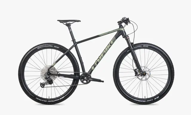 Czarny rower górski Unibike Evo z zielonymi akcentami, oponami Schwalbe Racing Ralph i Ray, gotowy na przygodę.