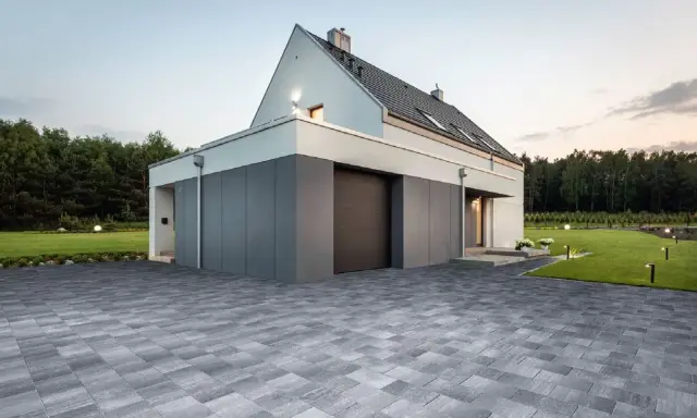 Nowoczesne projekty kostki brukowej wokół domu tworzą elegancką nawierzchnię podjazdu i tarasu, podkreślając architekturę.