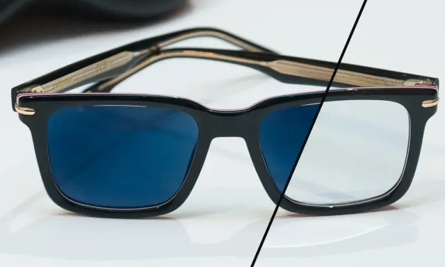 Eleganckie okulary z czarnymi oprawkami, po lewej stronie ciemne szkła fotochromowe, po prawej jasne.