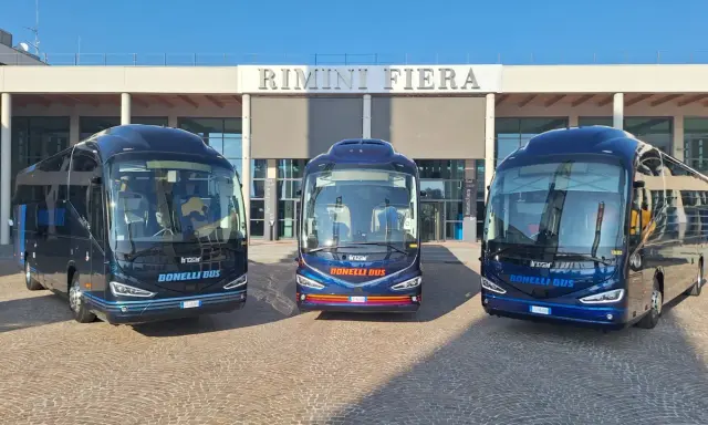 Tre bus Bonelli Bus blu scuro pronti per il viaggio da Rimini a San Marino, con la scritta "Rimini Fiera" sullo sfondo.