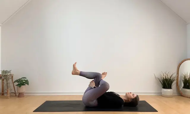 Frau in Yoga-Pose auf Matte, entspannt während ihrer Yoga-Periode.