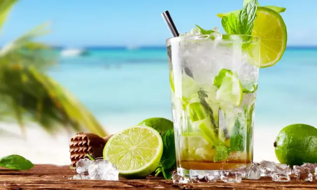 Orzeźwiający przepis na mojito z Bacardi na plaży. Lody, limonki i mięta w szklance.