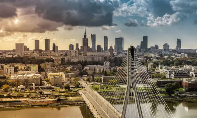 Warszawa słynie z nowoczesnej panoramy miasta z mostem Siekierkowskim i wieżowcami w tle, nad rzeką Wisłą.