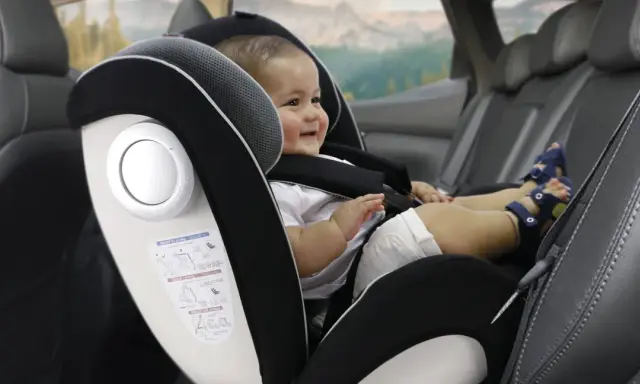 Bebé sonriente en silla de coche, grupo 0 hasta 18kg. Viaje seguro para los más pequeños.