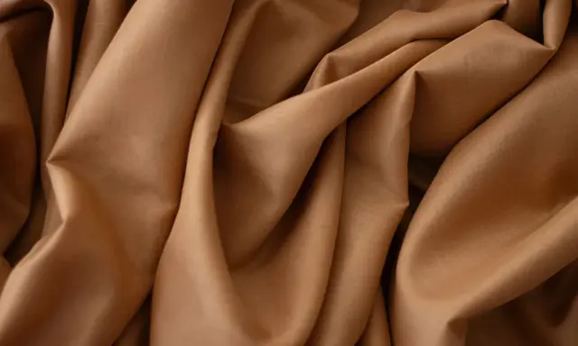 Tessuto in crepe color caramello, ideale per abiti eleganti, sia estivi che invernali, grazie alla sua caduta fluida.
