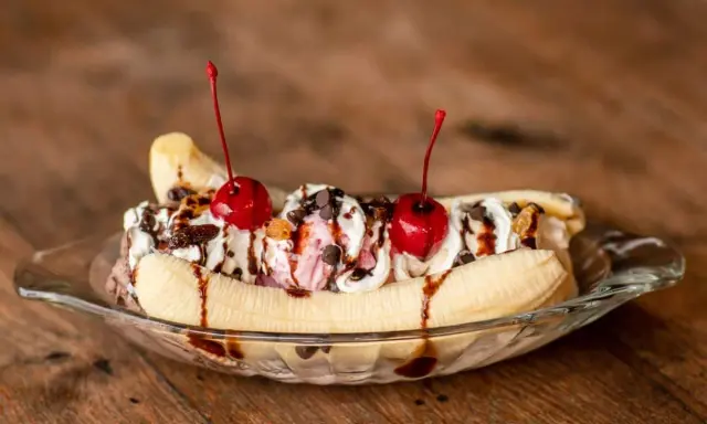 Un déliceux banana split avec glace, crème fouettée, pépites de chocolat et cerises. Une recette parfaite pour un dessert gourmand.