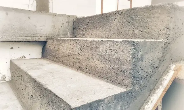 Surowe, betonowe stopnie schodowe w trakcie budowy. Solidna konstrukcja czeka na wykończenie.