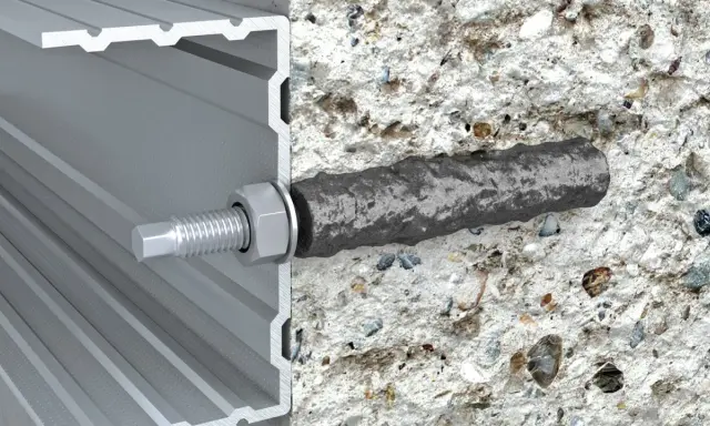 Przekrój profilu aluminiowego z widocznym elementem mocującym, który wchodzi w beton. To jest właśnie ankier – co to jest, widać na obrazku.