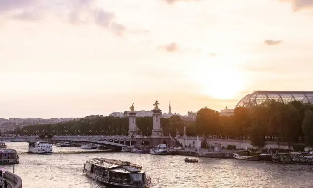 Boote auf der Seine bei Sonnenuntergang, eine malerische Szene, die die beste Reisezeit für Paris widerspiegelt.