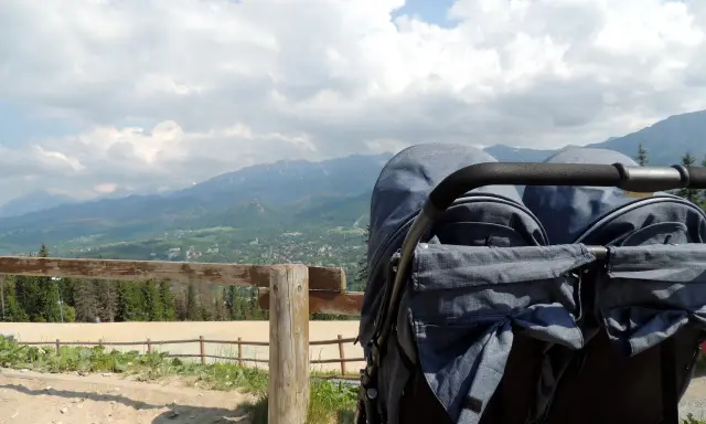 Podwójny wózek gotowy na przygodę. Zastanawiasz się, jakie szlaki z dzieckiem w Zakopanem są najlepsze? Ten widok na Tatry zachęca do odkrywania!