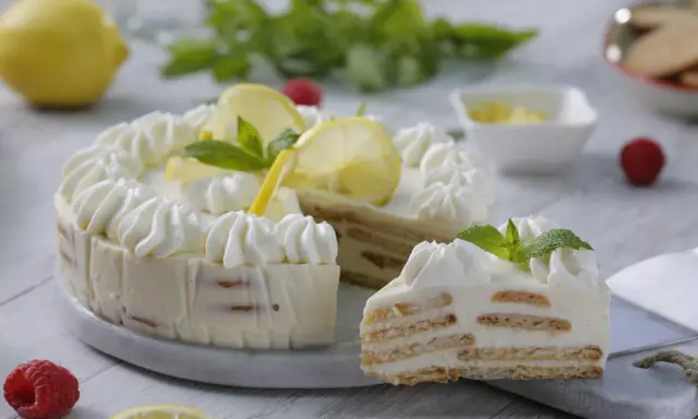 Delicioso mousse de limón con leche condensada, decorado con crema batida, rodajas de limón y menta.