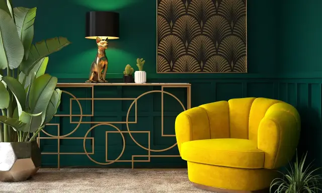 Eleganckie wnętrze w stylu art deco nowoczesny: złoty kot jako lampa, żółty fotel i geometryczne zdobienia na zielonej ścianie.