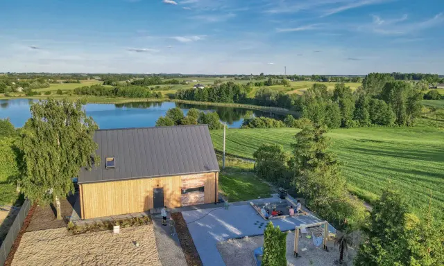 Nowoczesny dom na odludziu nad jeziorem, z piaskową plażą i miejscem do grillowania. Idealne miejsce na wypoczynek.
