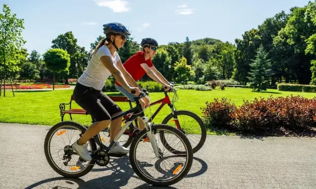 Dwie osoby na rowerach cieszą się słonecznym dniem w parku. Ile czasu zajmie im przejechanie 20 km rowerem?