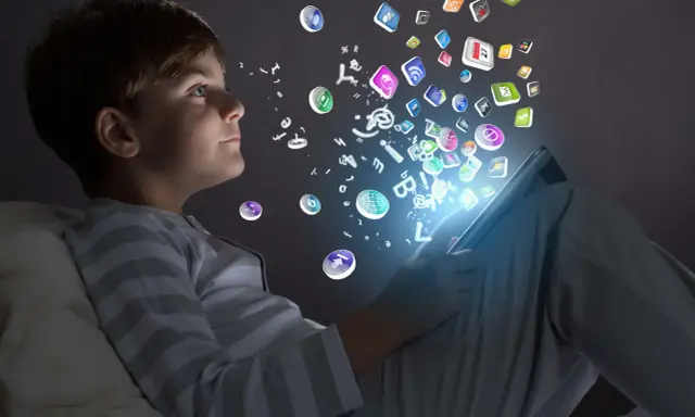 Niño de la generación alfa interactuando con iconos de aplicaciones y letras que flotan desde una tablet.