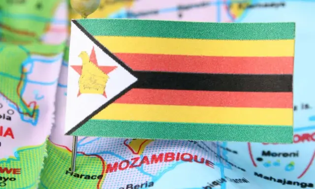 Flaga Zimbabwe na mapie, symbolizująca trudności gospodarcze i inflację.