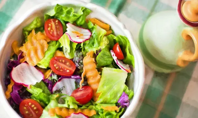 Unas frescas ensaladas de verano con lechuga, tomate, rábano y zanahoria rallada, listas para disfrutar.