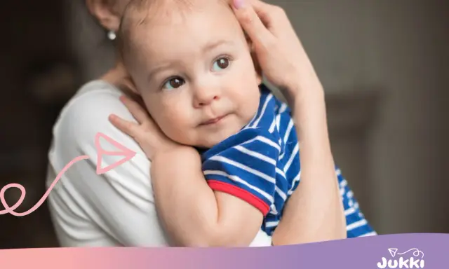 Ciepły uścisk mamy, kiedy dziecko świadomie się przytula. Maluch w pasiastej bluzeczce wtula się w ramiona.