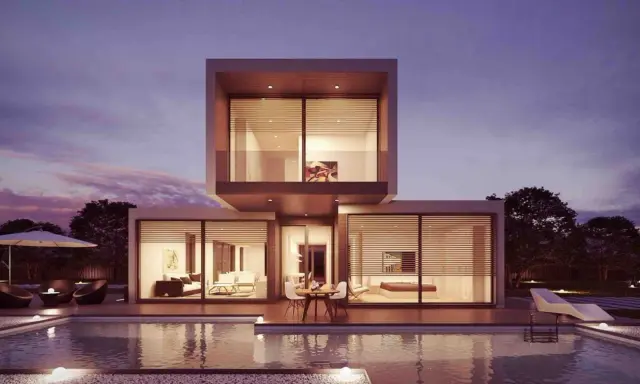 Moderne Villa mit Pool und Terrasse, ideal für den Hausbau planen. Beleuchtete Innenräume und ein schöner Abendhimmel.